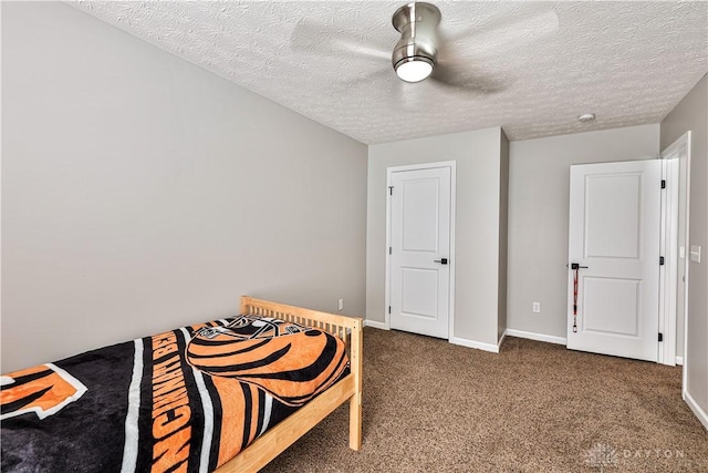 bedroom with carpet flooring, a textured ceiling, a ceiling fan, and baseboards