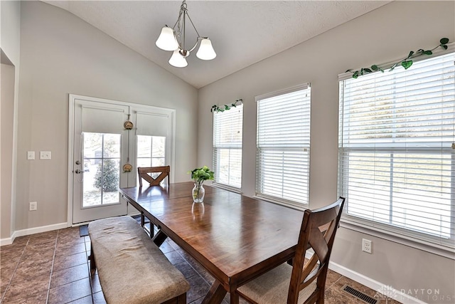 dining room featuring visible vents, a notable chandelier, tile patterned flooring, baseboards, and vaulted ceiling