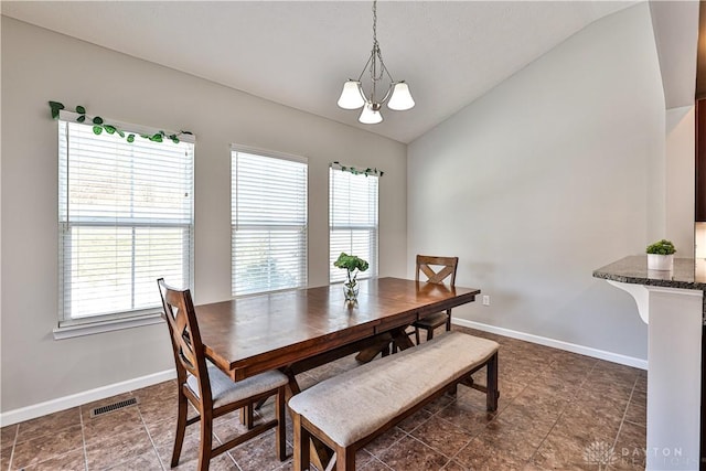 dining room with visible vents, baseboards, a healthy amount of sunlight, and vaulted ceiling