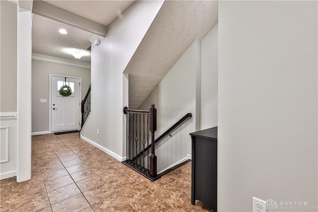 tiled foyer entrance with baseboards and crown molding