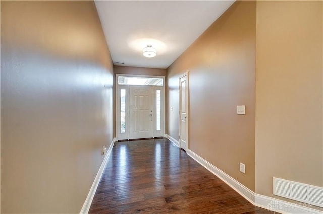 doorway featuring dark wood-style floors, visible vents, and baseboards