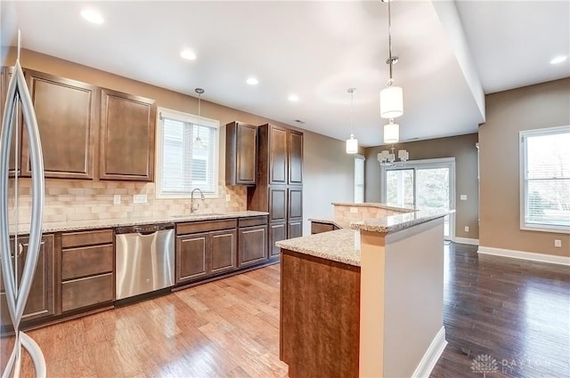 kitchen featuring plenty of natural light, backsplash, appliances with stainless steel finishes, and a sink