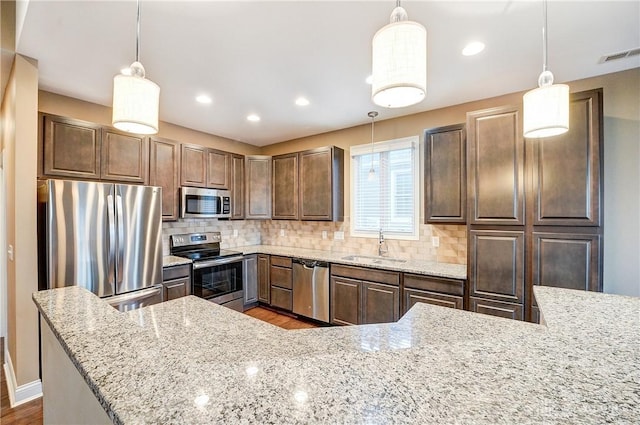 kitchen featuring a sink, decorative backsplash, appliances with stainless steel finishes, and visible vents