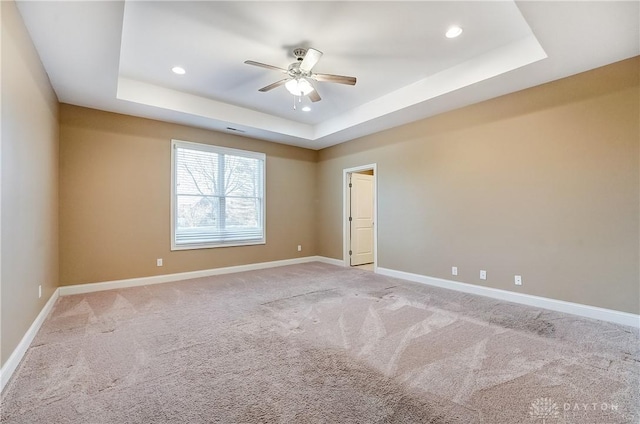 carpeted spare room with recessed lighting, baseboards, a raised ceiling, and a ceiling fan