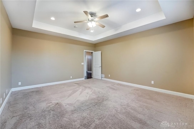 spare room featuring recessed lighting, baseboards, a raised ceiling, and a ceiling fan