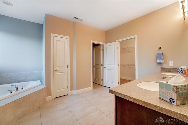 bathroom featuring a sink, visible vents, a bath, and tile patterned flooring