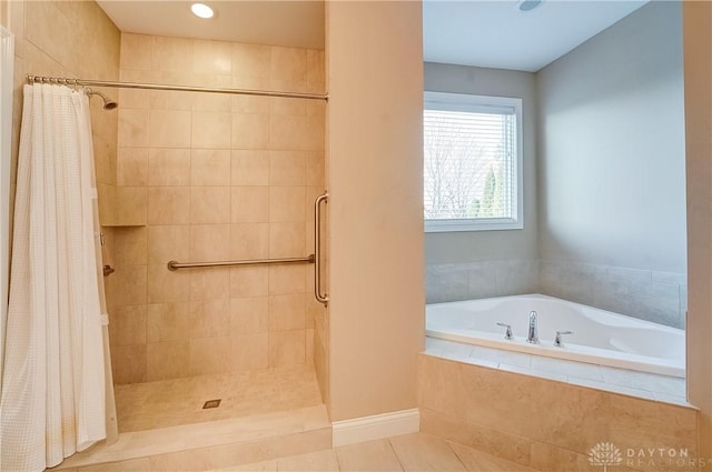 bathroom featuring tile patterned floors, a bath, and tiled shower