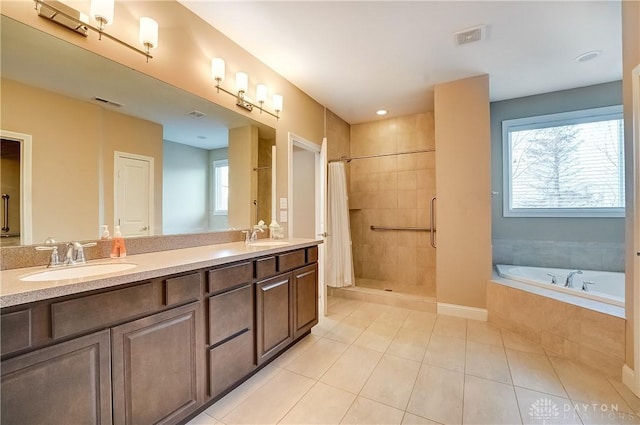 full bath with a sink, a wealth of natural light, and a bath