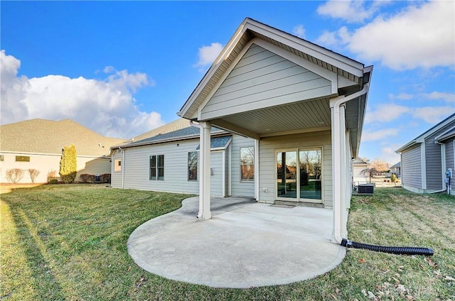 rear view of house featuring central AC unit, a yard, and a patio area