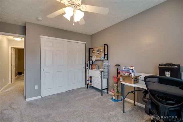 office with carpet, baseboards, and a textured ceiling