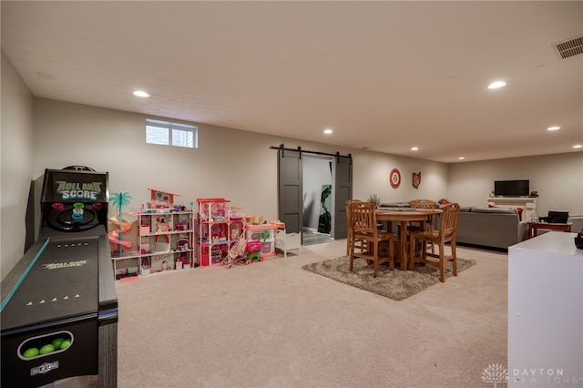 rec room featuring light colored carpet, a barn door, recessed lighting, and visible vents