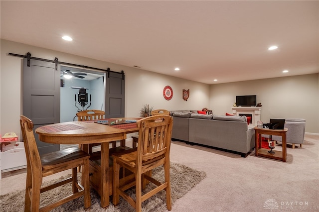 dining room featuring light carpet, recessed lighting, and a barn door