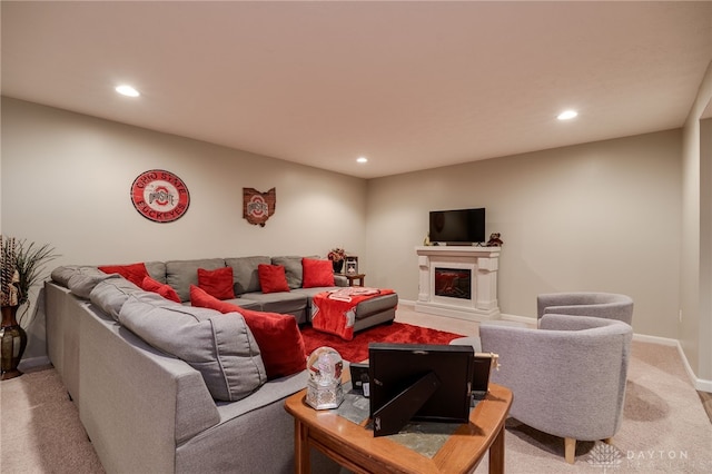 living area with a glass covered fireplace, recessed lighting, baseboards, and light colored carpet