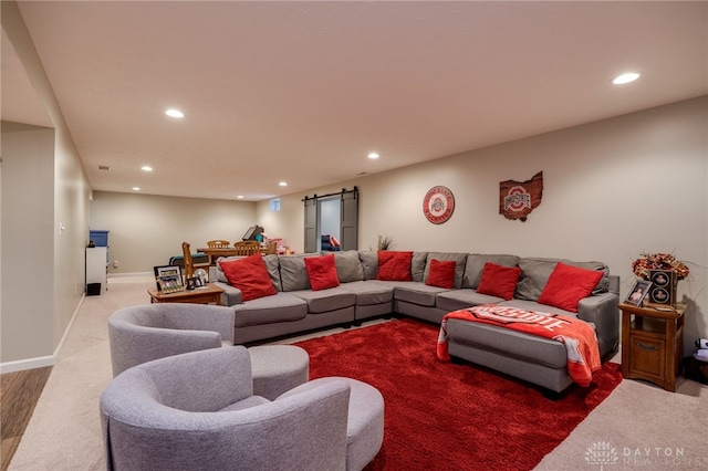 carpeted living room with recessed lighting, a barn door, and baseboards