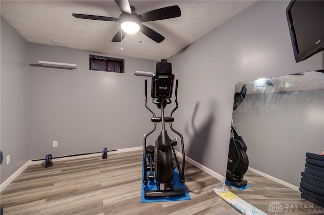 exercise area featuring baseboards and wood finished floors