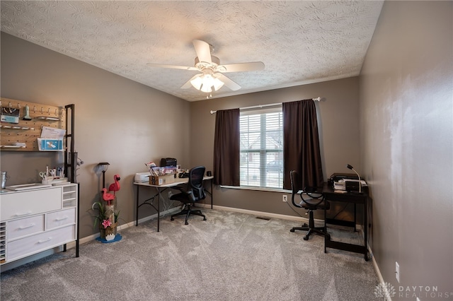 carpeted office space with baseboards, a textured ceiling, and a ceiling fan