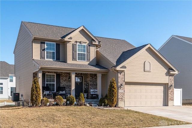 view of front of house featuring a porch, concrete driveway, a front yard, a garage, and central AC unit