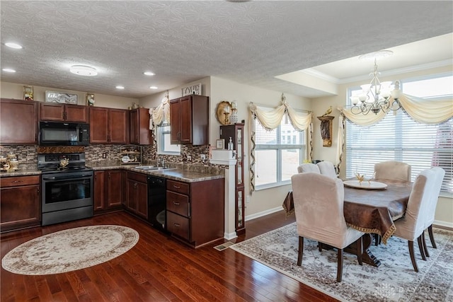 kitchen with dark wood finished floors, an inviting chandelier, a sink, black appliances, and backsplash