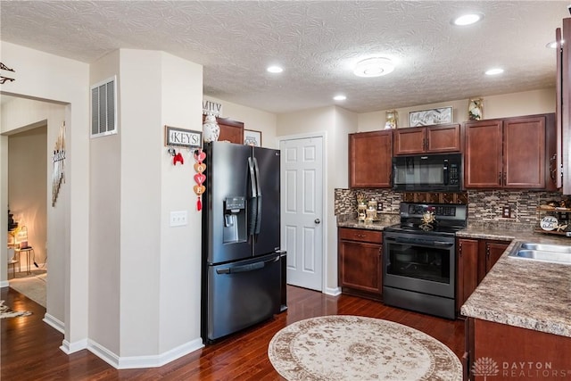 kitchen featuring black appliances, tasteful backsplash, dark wood-style floors, and visible vents