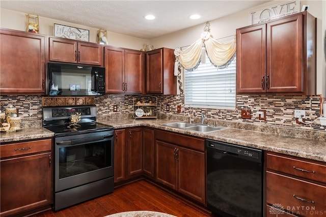 kitchen featuring tasteful backsplash, dark wood-type flooring, recessed lighting, black appliances, and a sink