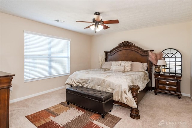 bedroom with visible vents, light carpet, baseboards, and ceiling fan