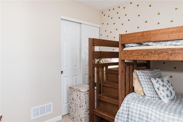 carpeted bedroom with a closet and visible vents