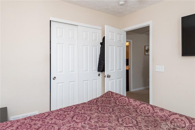 unfurnished bedroom with a closet, visible vents, carpet floors, and a textured ceiling