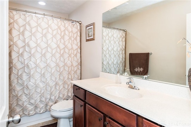 full bathroom featuring recessed lighting, a textured ceiling, toilet, and vanity