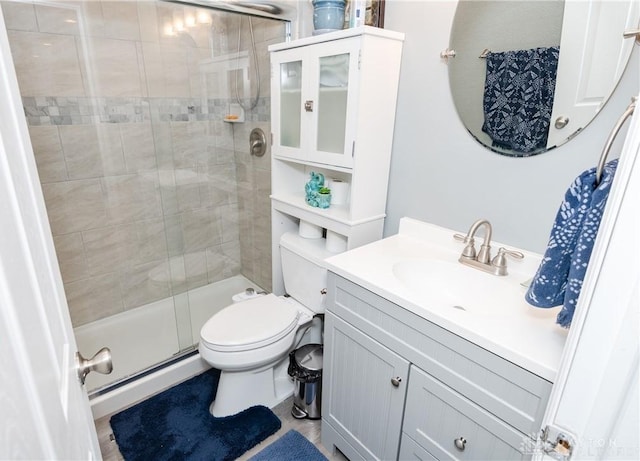 bathroom featuring a stall shower, toilet, and vanity