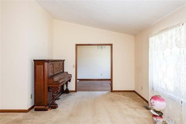 empty room with lofted ceiling, baseboards, and carpet floors