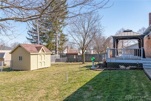 view of yard with a gazebo, a deck, a fenced backyard, an outdoor structure, and a storage unit