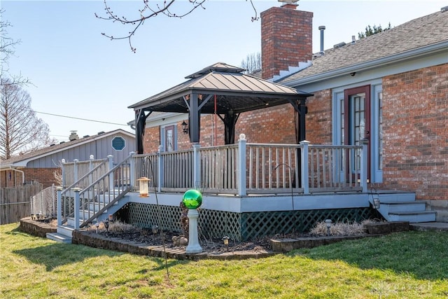 wooden terrace with a gazebo, a lawn, and fence