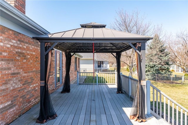 wooden terrace featuring a gazebo, a yard, and fence