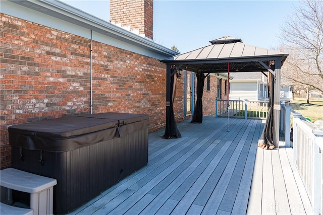 wooden deck with a gazebo and a hot tub