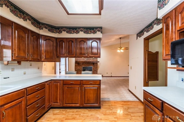 kitchen with light countertops, black microwave, and ceiling fan