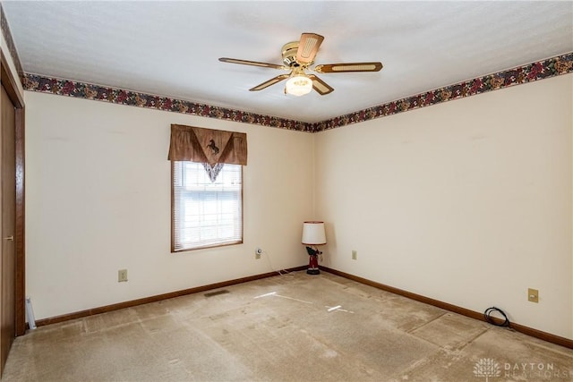 spare room featuring visible vents, baseboards, light carpet, and ceiling fan