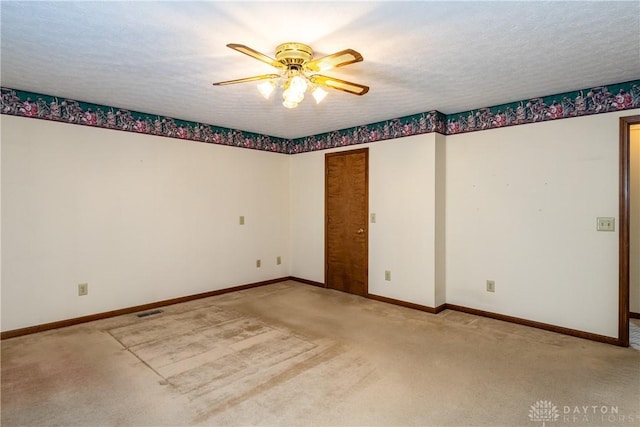 spare room with visible vents, carpet floors, a textured ceiling, and baseboards