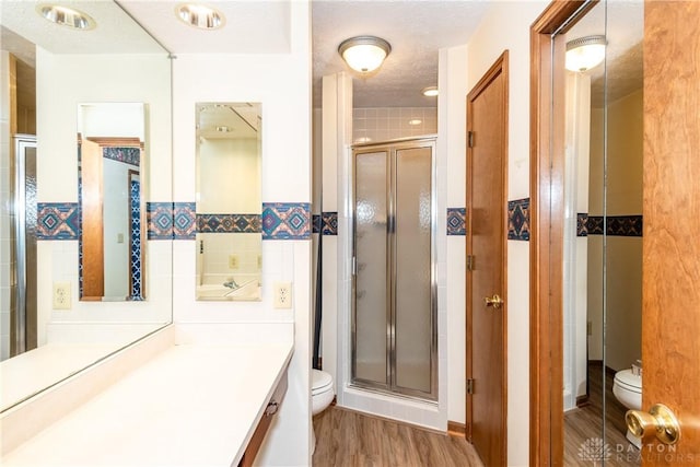 bathroom featuring toilet, tile walls, and a stall shower