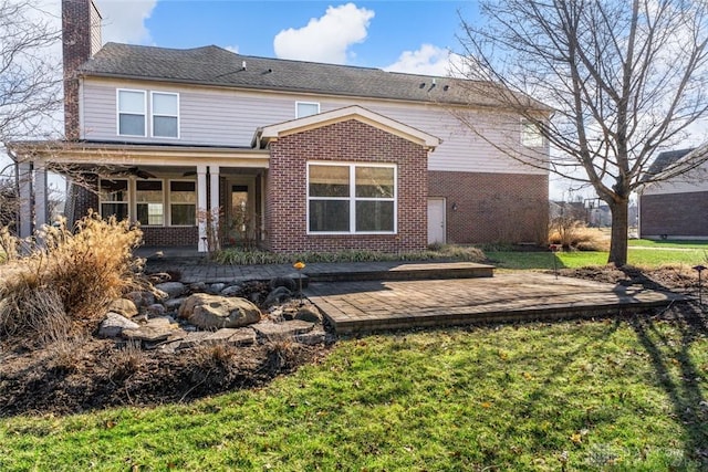 back of house with a yard, brick siding, and a chimney