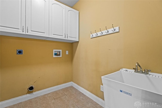 washroom featuring electric dryer hookup, a sink, cabinet space, light tile patterned floors, and hookup for a washing machine