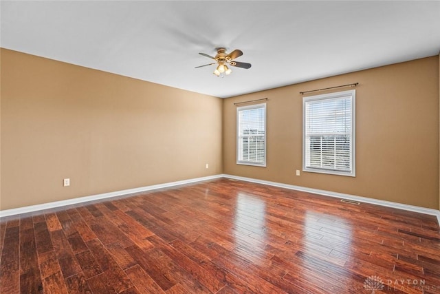 spare room with wood finished floors, baseboards, and ceiling fan