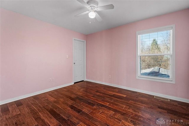 unfurnished room featuring ceiling fan, visible vents, baseboards, and dark wood finished floors