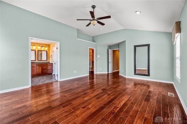 unfurnished bedroom featuring visible vents, baseboards, wood finished floors, and vaulted ceiling