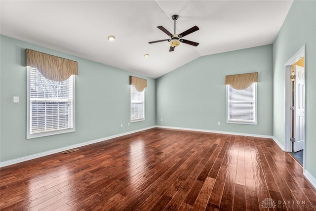 empty room with baseboards, wood finished floors, a ceiling fan, and vaulted ceiling