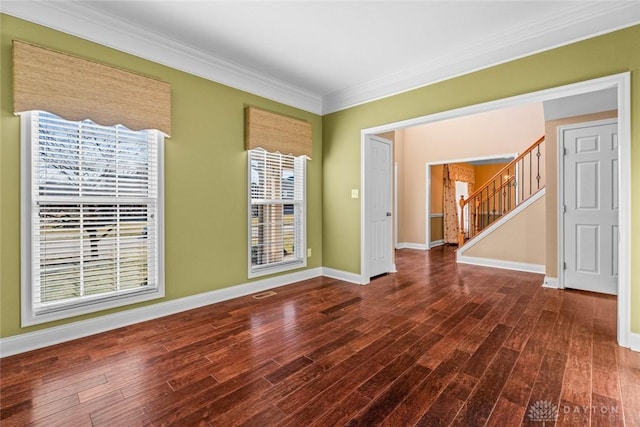 unfurnished room with stairs, crown molding, wood finished floors, and baseboards