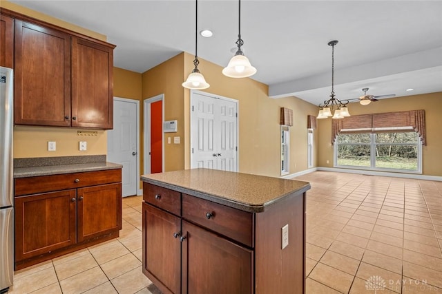 kitchen with dark countertops, decorative light fixtures, light tile patterned floors, and open floor plan