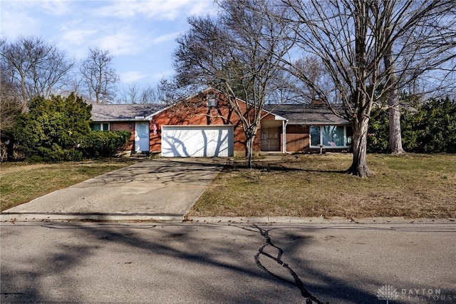 view of front facade featuring brick siding, an attached garage, concrete driveway, and a front lawn