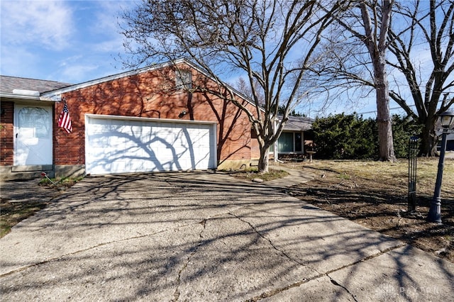 view of front of property featuring aphalt driveway, brick siding, and an attached garage