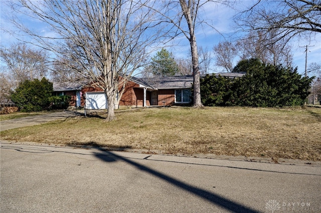 view of front of house featuring concrete driveway, brick siding, a garage, and a front lawn