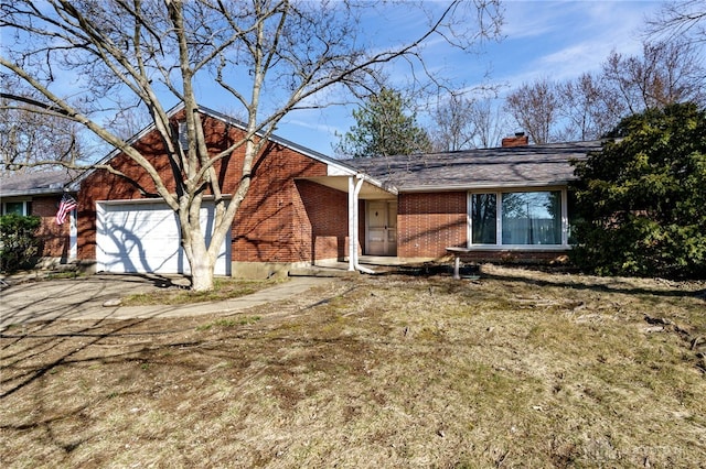 view of front facade with a garage, brick siding, driveway, and a chimney